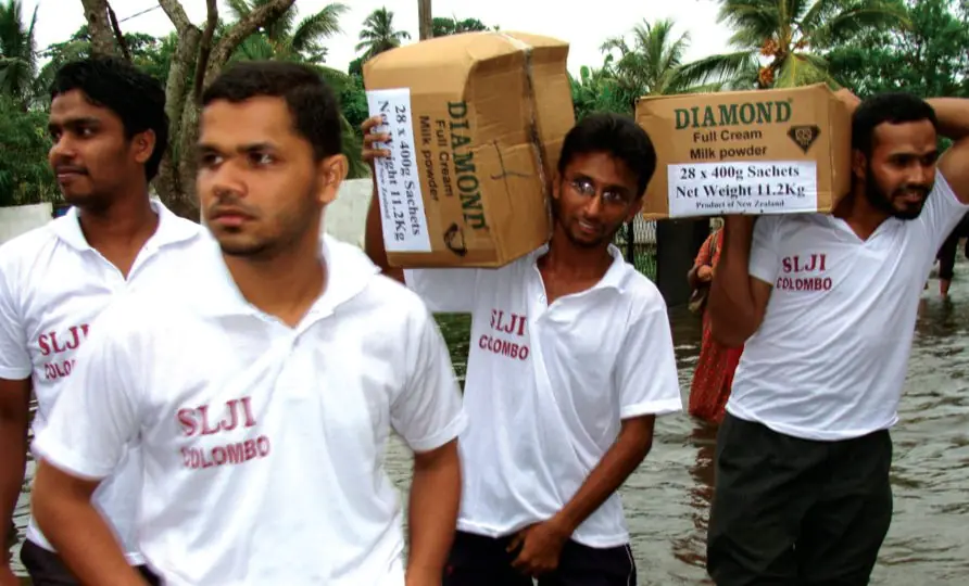 SLJI volunteers carrying relief supplies